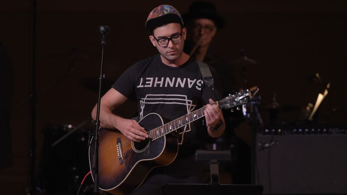 Stevens holding guitar on stage