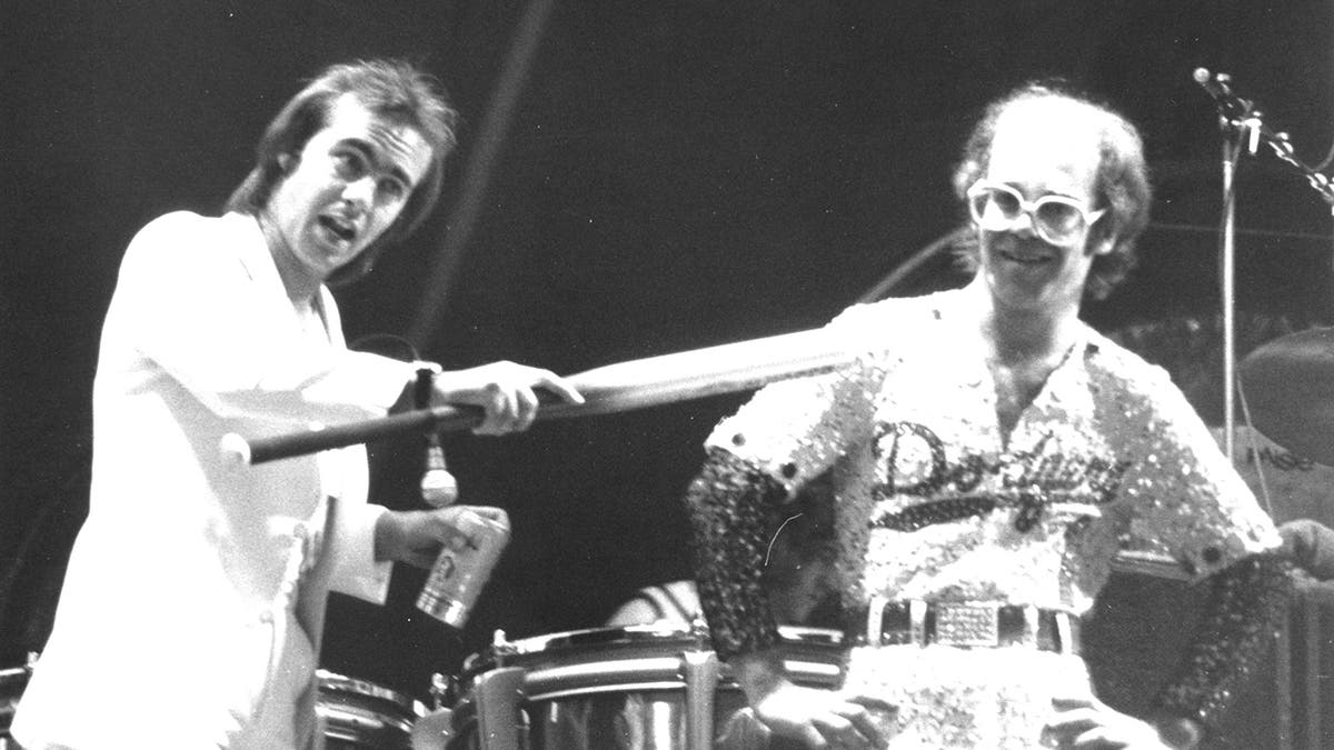 Elton John and Bernie Taupin joking around on stage