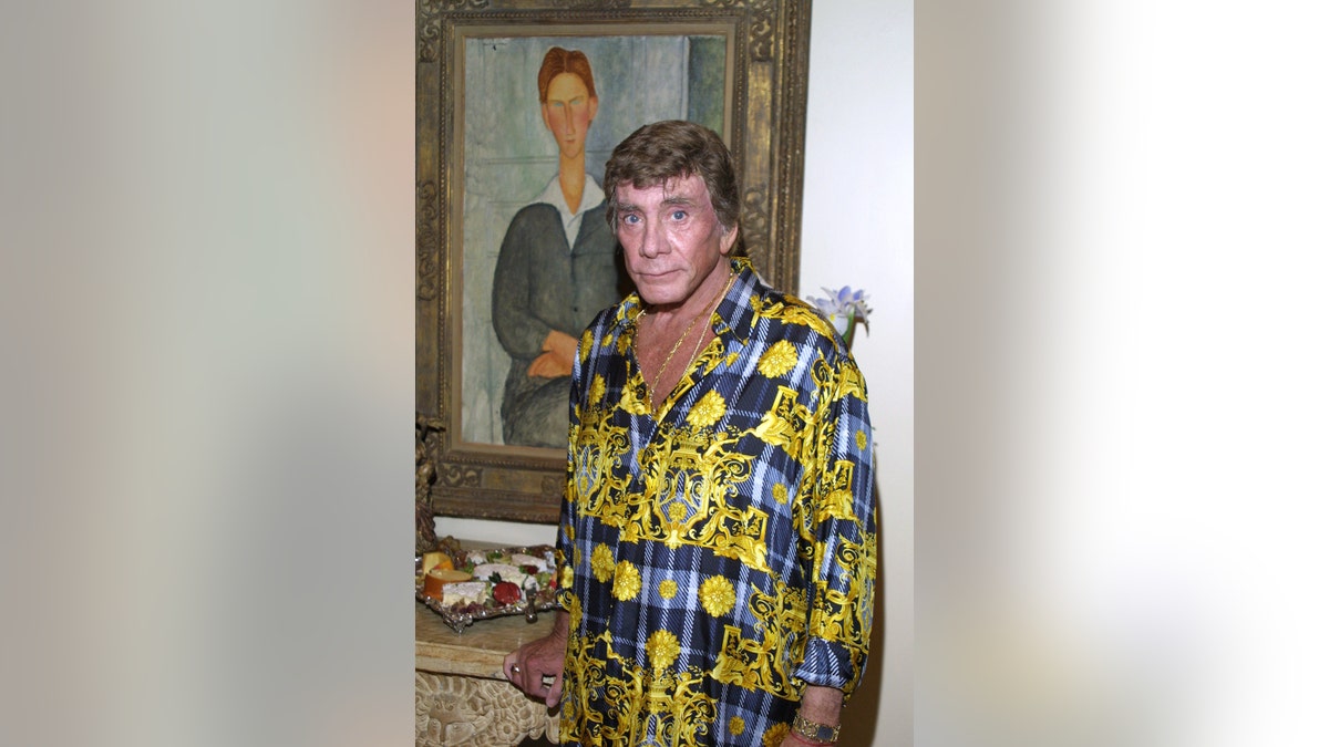 Bob Guccione wearing a gold and blue plaid blouse