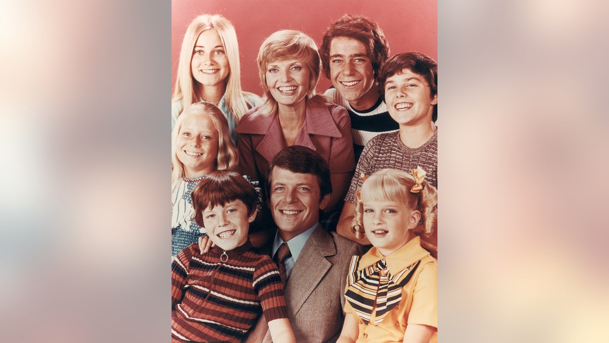O elenco do Brady Bunch, todos sorrindo juntos em uma foto antiga