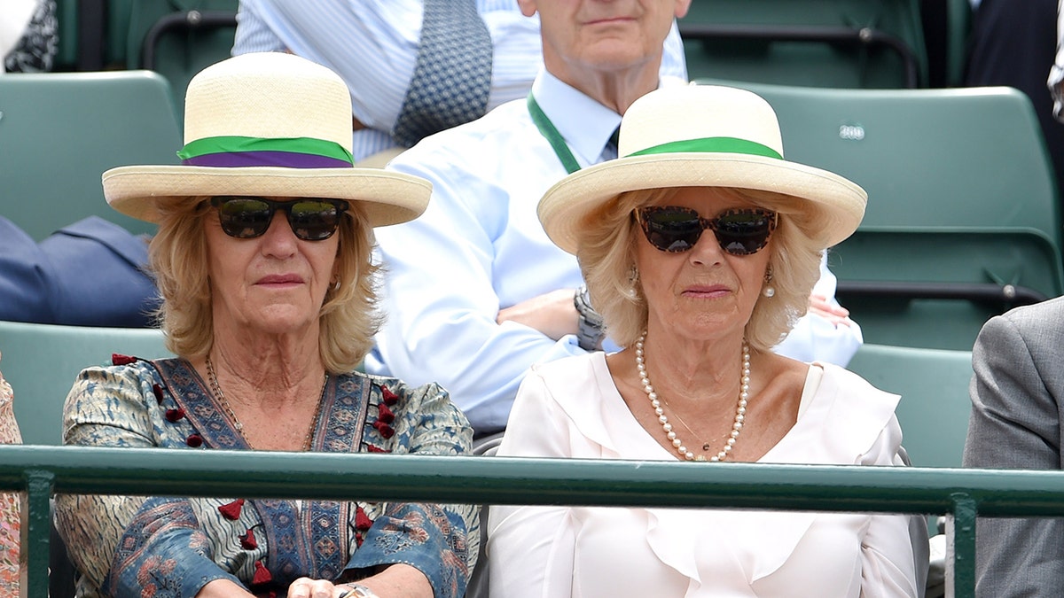 Annabel Elliot and her sister Camilla wearing matching straw hats with a green ribbon