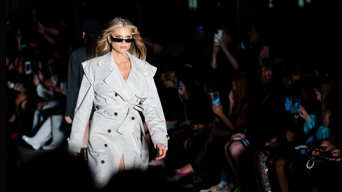 Charlotte McKinney modeling a trench coat on the runway