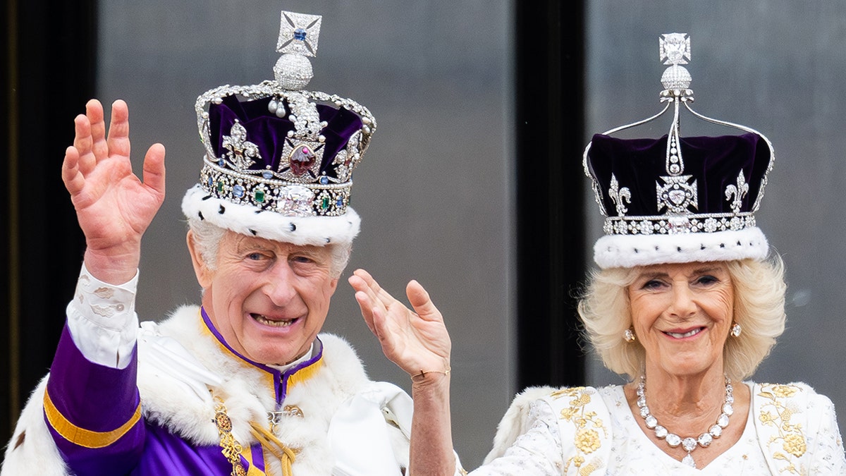 A close-up of King Charles and Queen Camilla waving and wearing their crowns