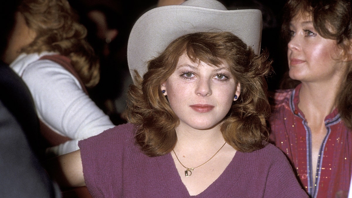 Dawn Lyn wearing a purple shirt and a cowboy hat