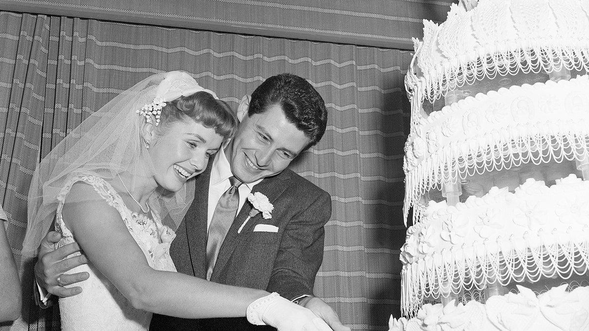 Debbie Reynolds and Eddie Fisher cutting cake on their wedding day