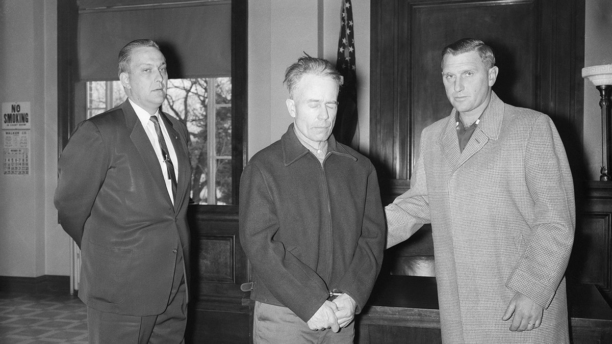 Ed Gein being escorted in court by officers