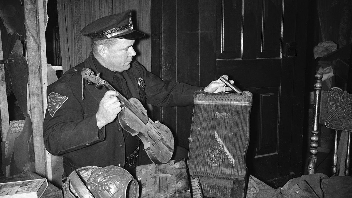 Police holding a violin and a box