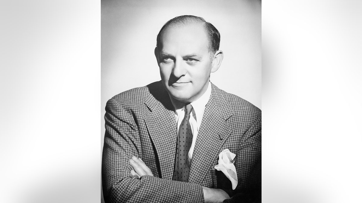 Harry Cohn wearing a suit with his arms crossed