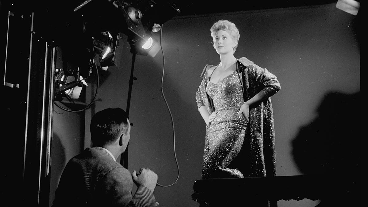 Kim Novak posing for a portait in front of a photographer