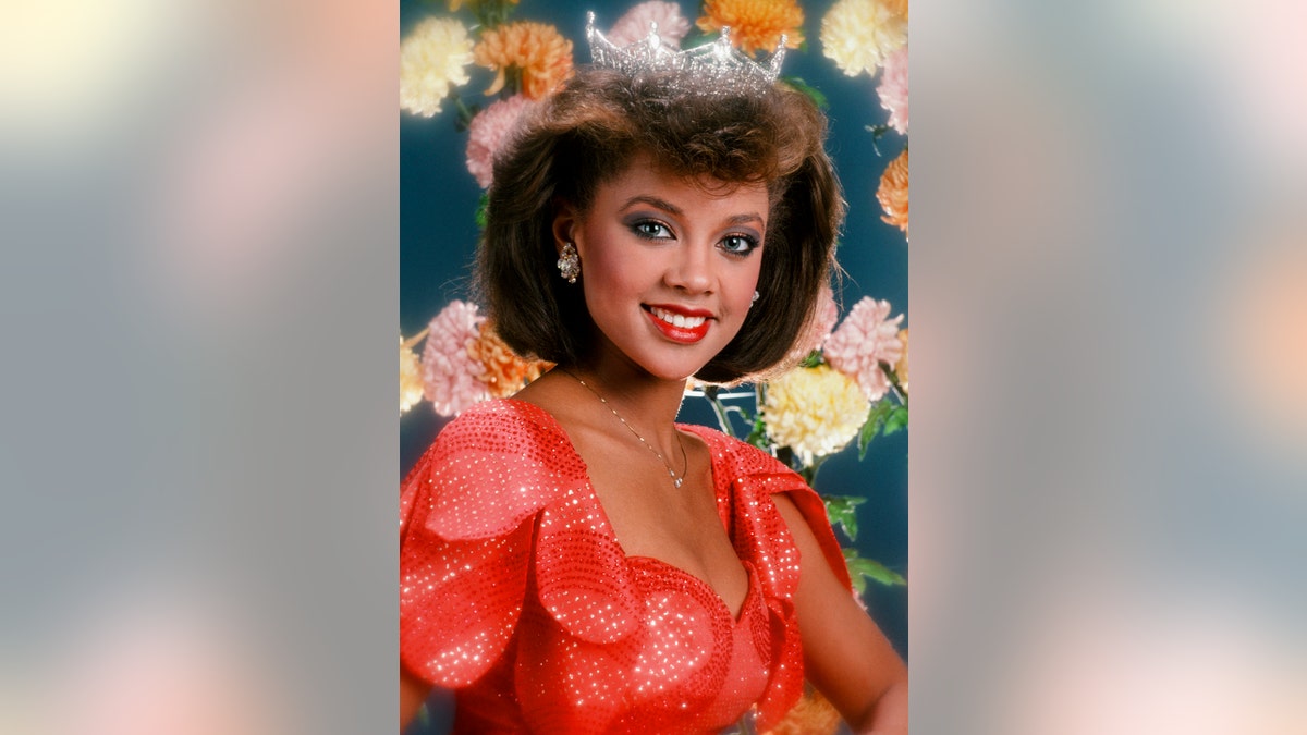 Vanessa Williams wearing a sparkling red dress and crown