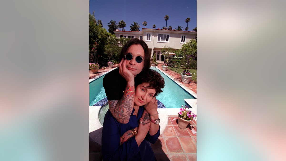 Ozzy and Sharon Osbourne embracing each other in front of their pool