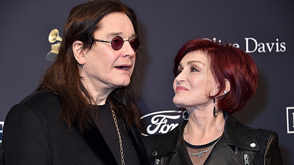Sharon Osbourne looking up at Ozzy Osbourne as they both wear black