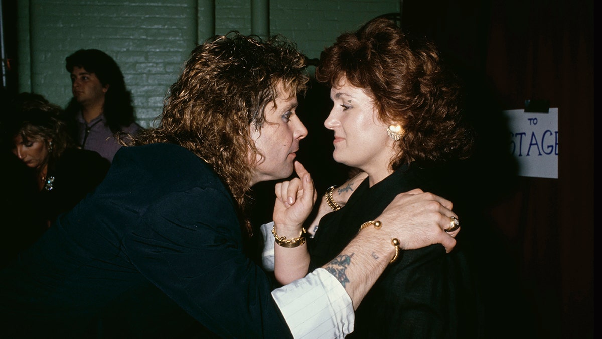 Ozzy Osbourne olhando para sua esposa Sharon enquanto ela toca seu rosto