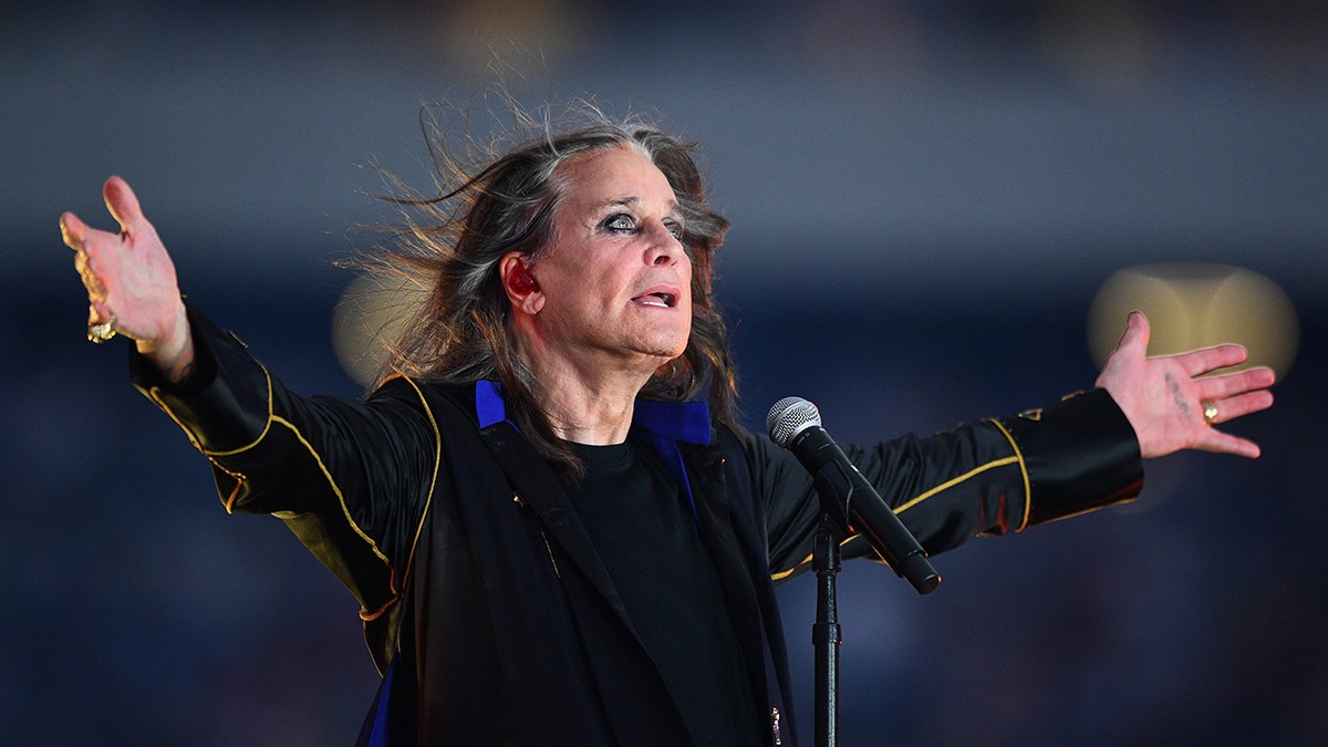 A close-up of Ozzy Osbourne performing on stage in black