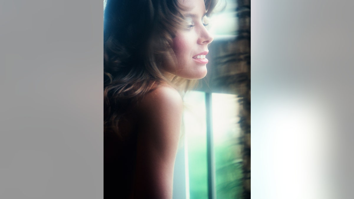 Corinne Alphen looking at a window away from the camera