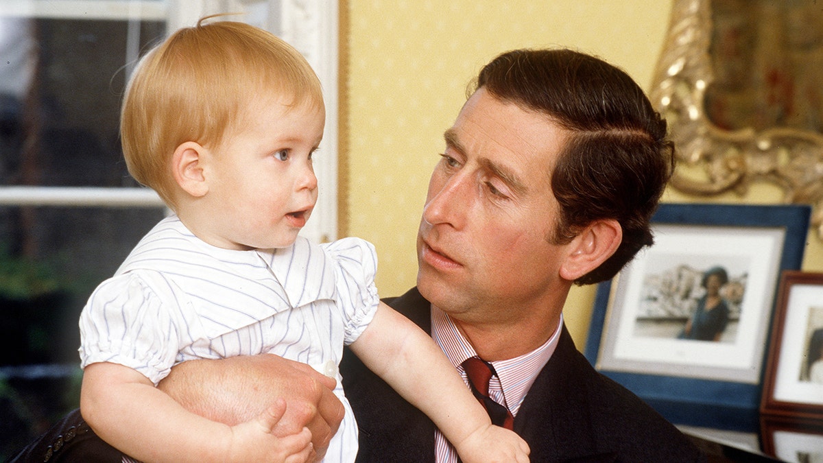 Prince Charles holding Prince Harry