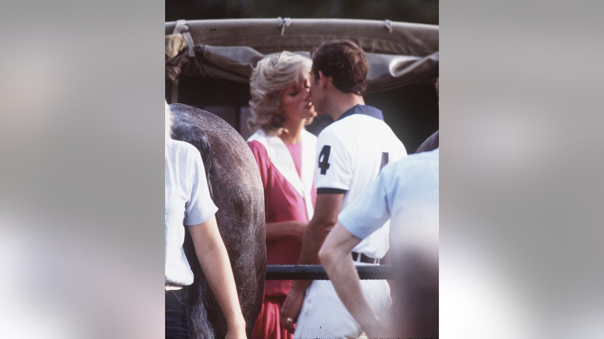 Princess Diana kissing Prince Charles on a polo field