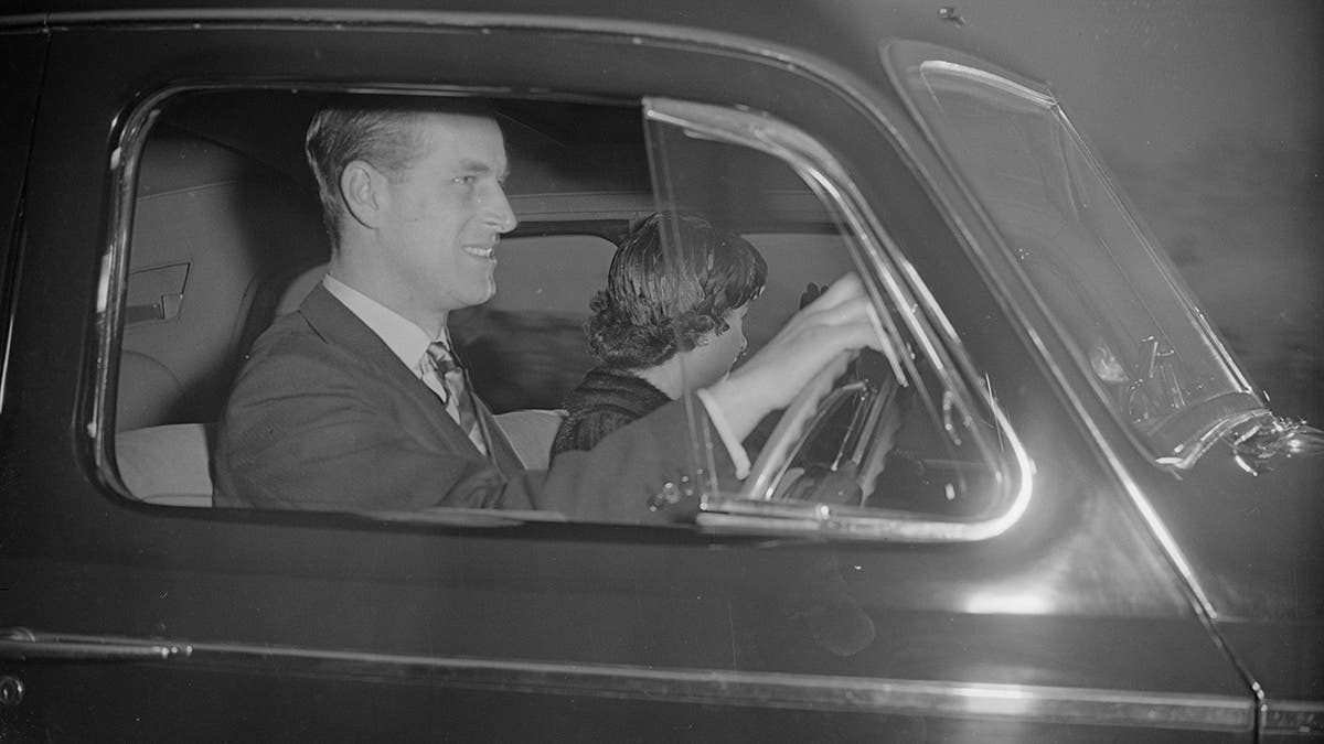 Prince Philip driving his car with Princess Elizabeth sitting next to him