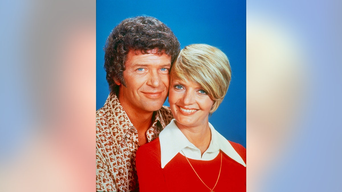 A close-up of Robert Reed and Florence Henderson canoodling