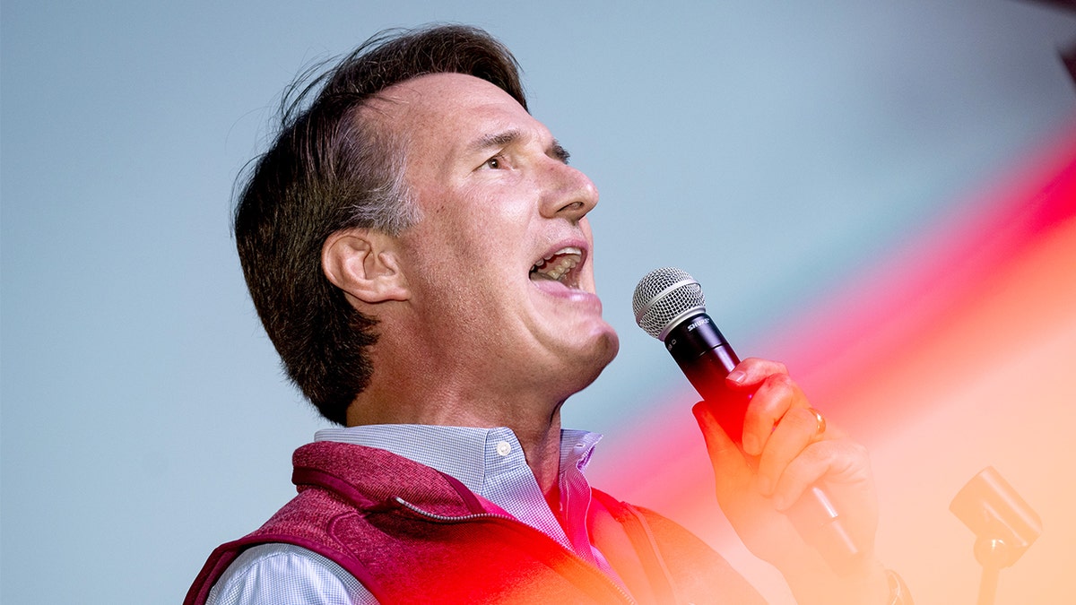 Virginia Gov. Glenn Youngkin holding microphone