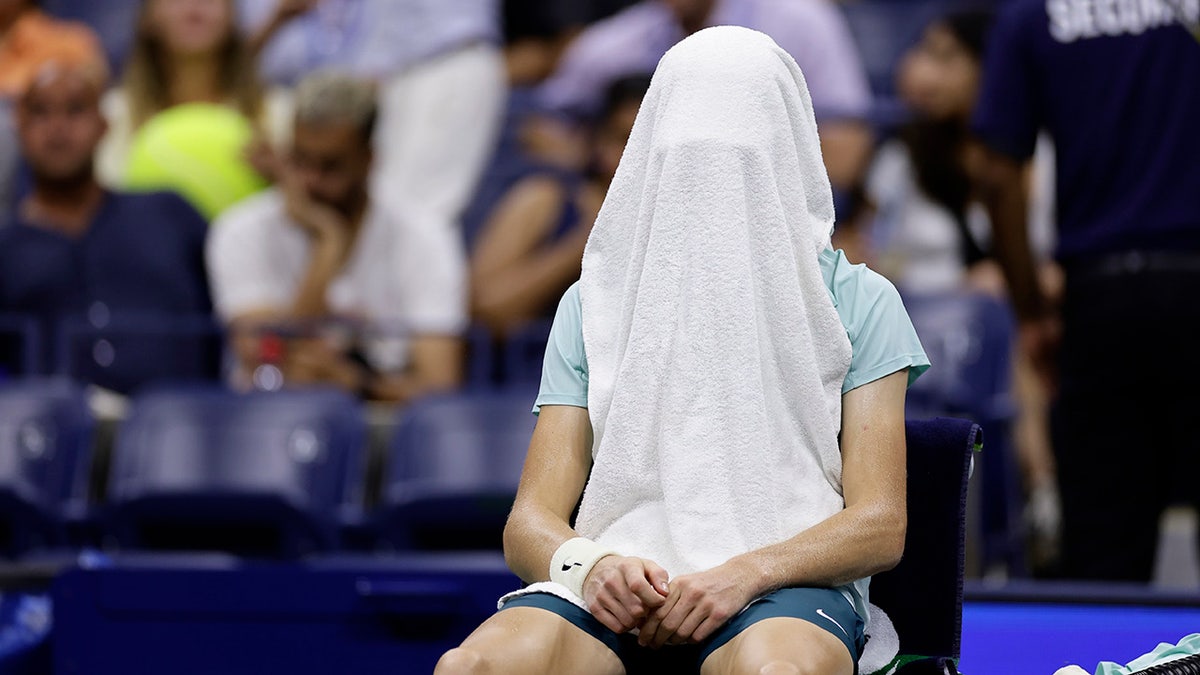 Jannik Sinner with a towel on his head