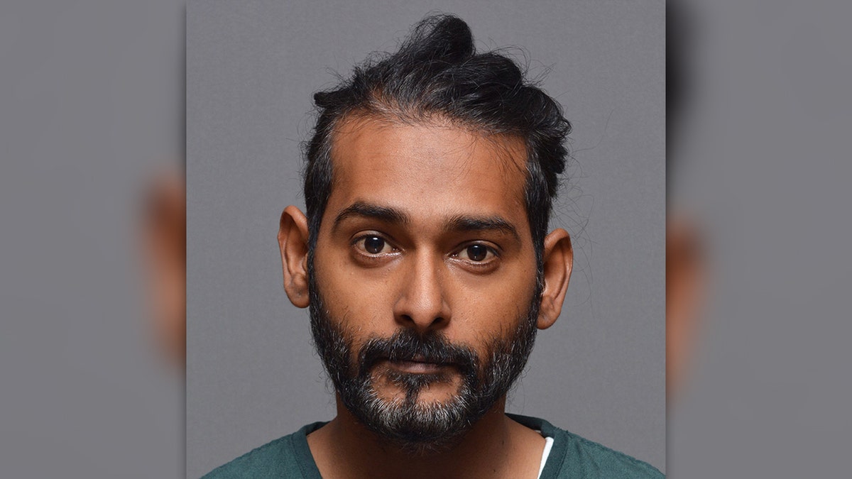 Javesh Persaud has graying black beard wearing a green T-shirt in his mugshot