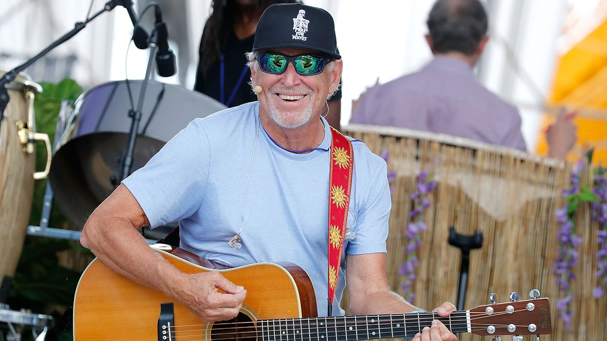 Jimmy Buffett playing guitar on stage