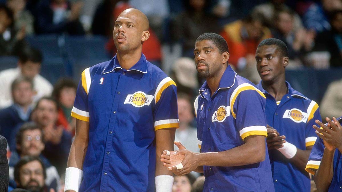 Kareem Abdul-Jabbar stands next to Magic Johnson