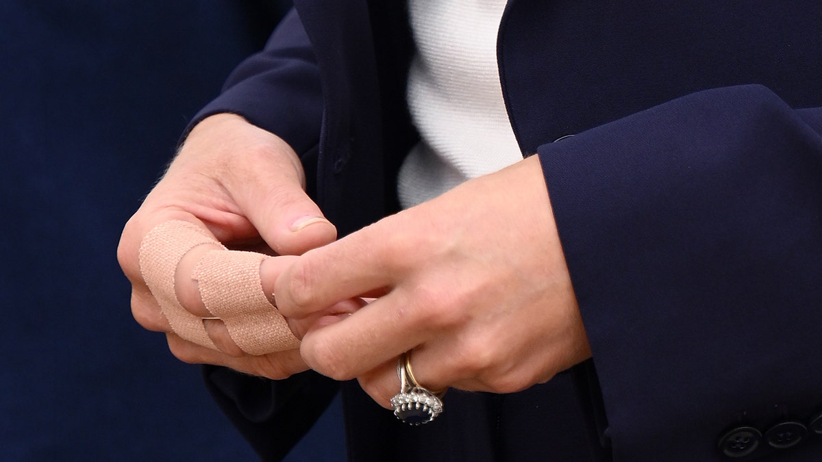Close up of Kate Middleton's hands, including ring and light medical tape