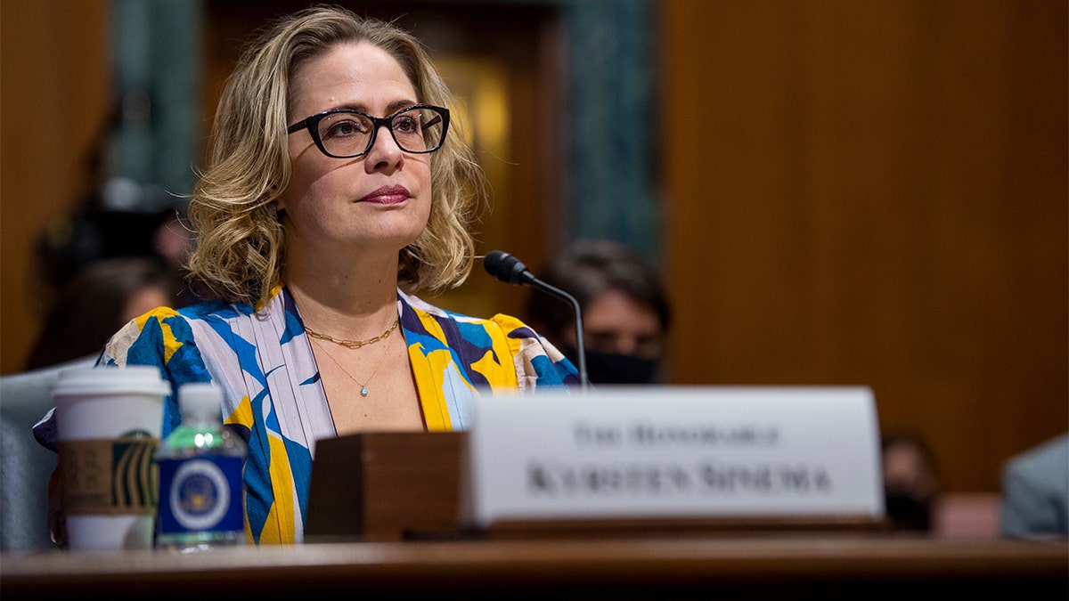 Sen. Kyrsten Sinema sitting in a Senate committee