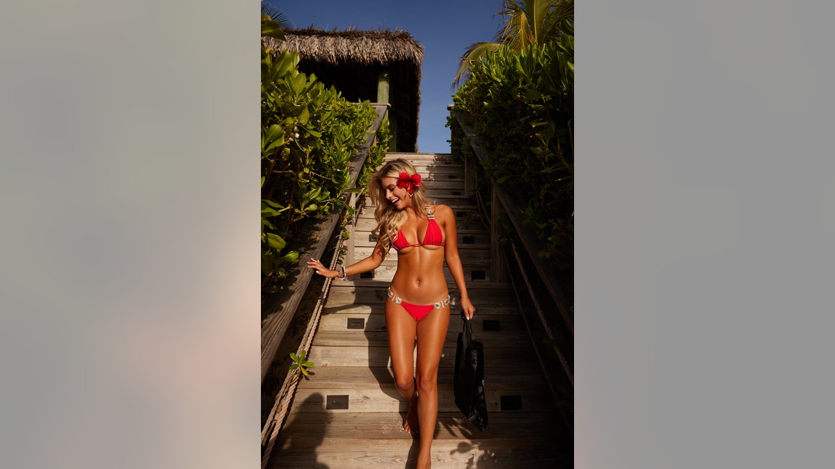 Madisyn Shipman going down stairs in a red bikini