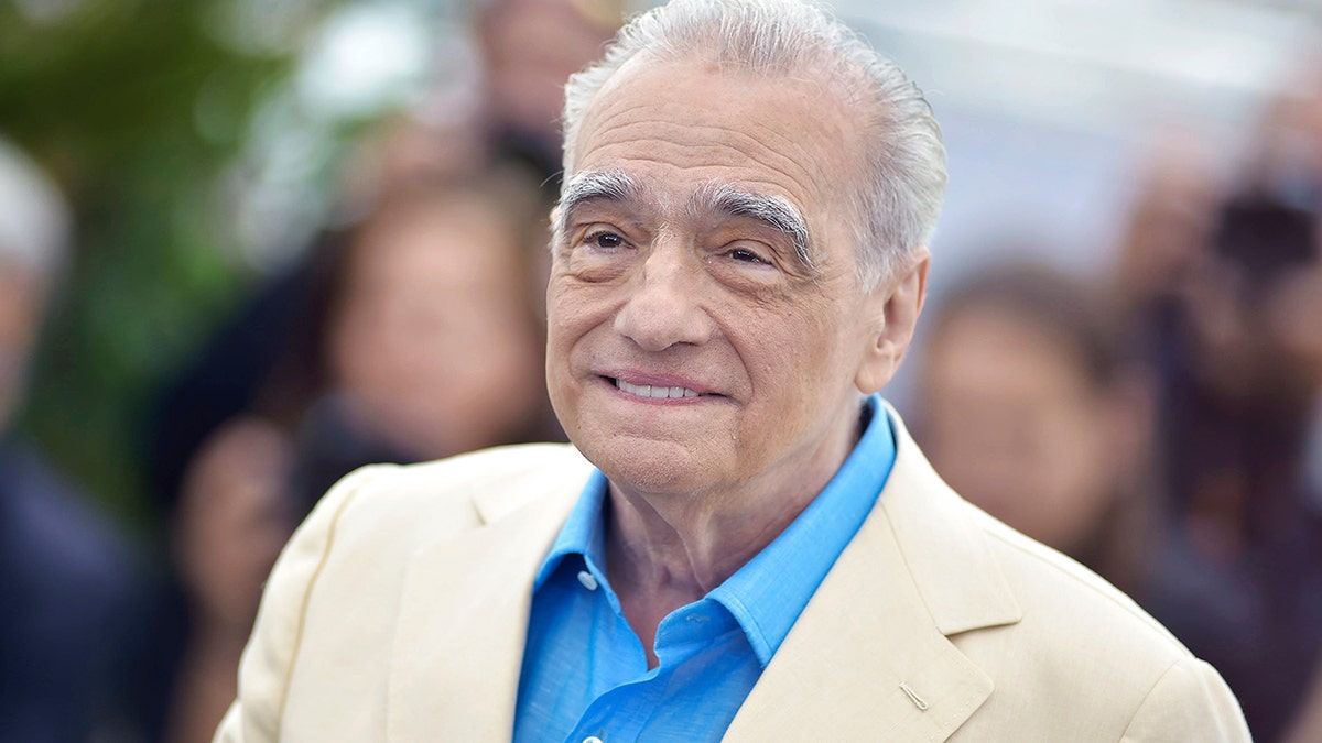 Martin Scorsese smiling in a white suit