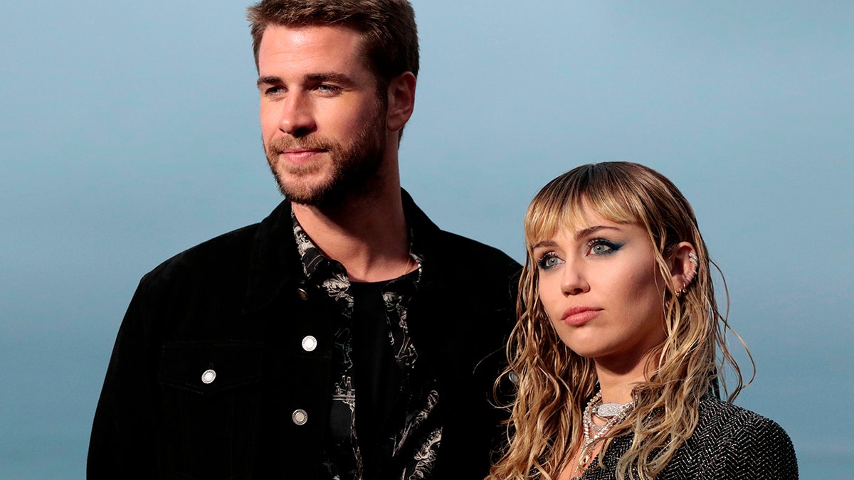 LIam Hemsworth and Miley Cyrus posing together