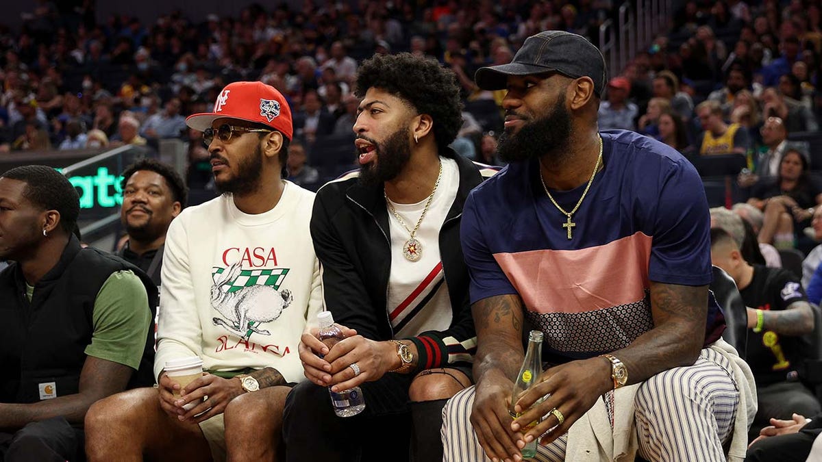Anthony Davis and LeBron James sit on the bench