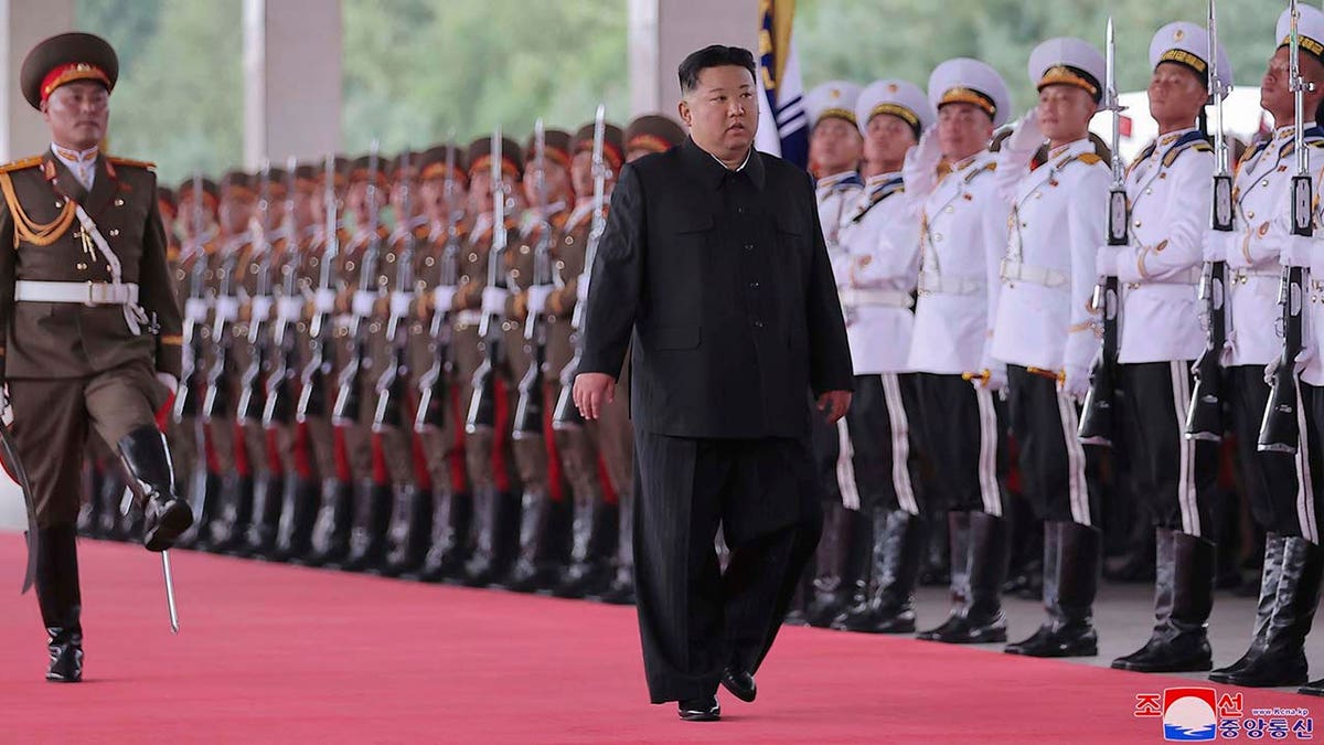 Kim Jong Un walking near military personnel 