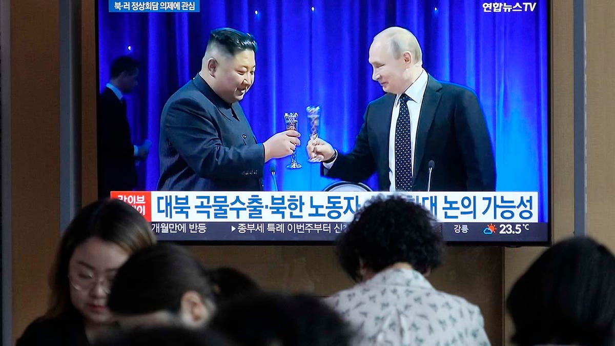 TV screen shows image of North Korean leader Kim Jong Un, left, and Russian President Vladimir Putin
