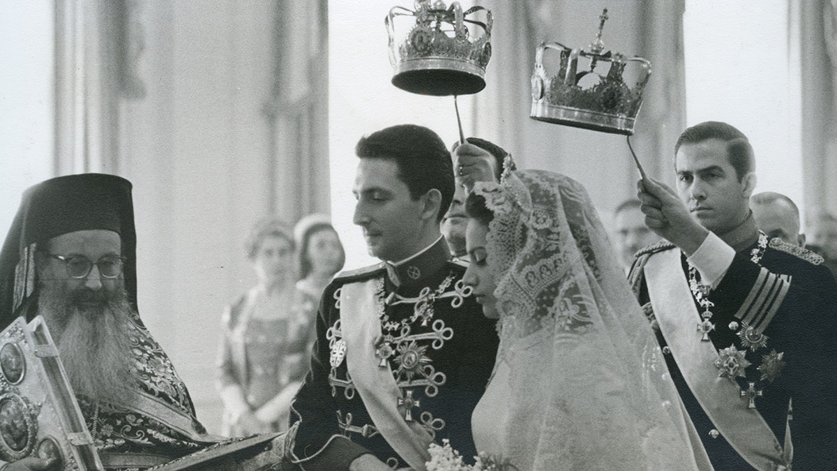 Prince Michael of Greece and Marina Karella on their wedding day with crowns above their heads
