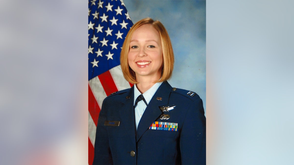 Sarah Lamp in a navy uniform posing in front of the American flag