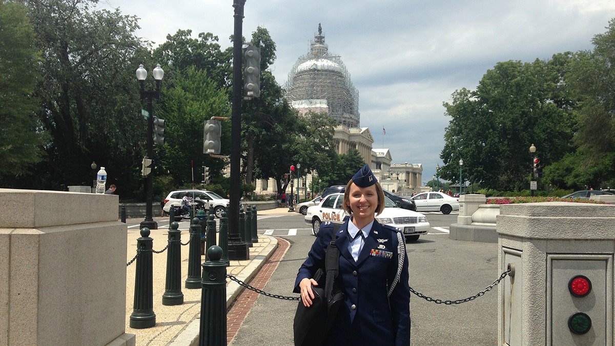 Sarah Lamp in a dark blue uniform standing in front of the White House