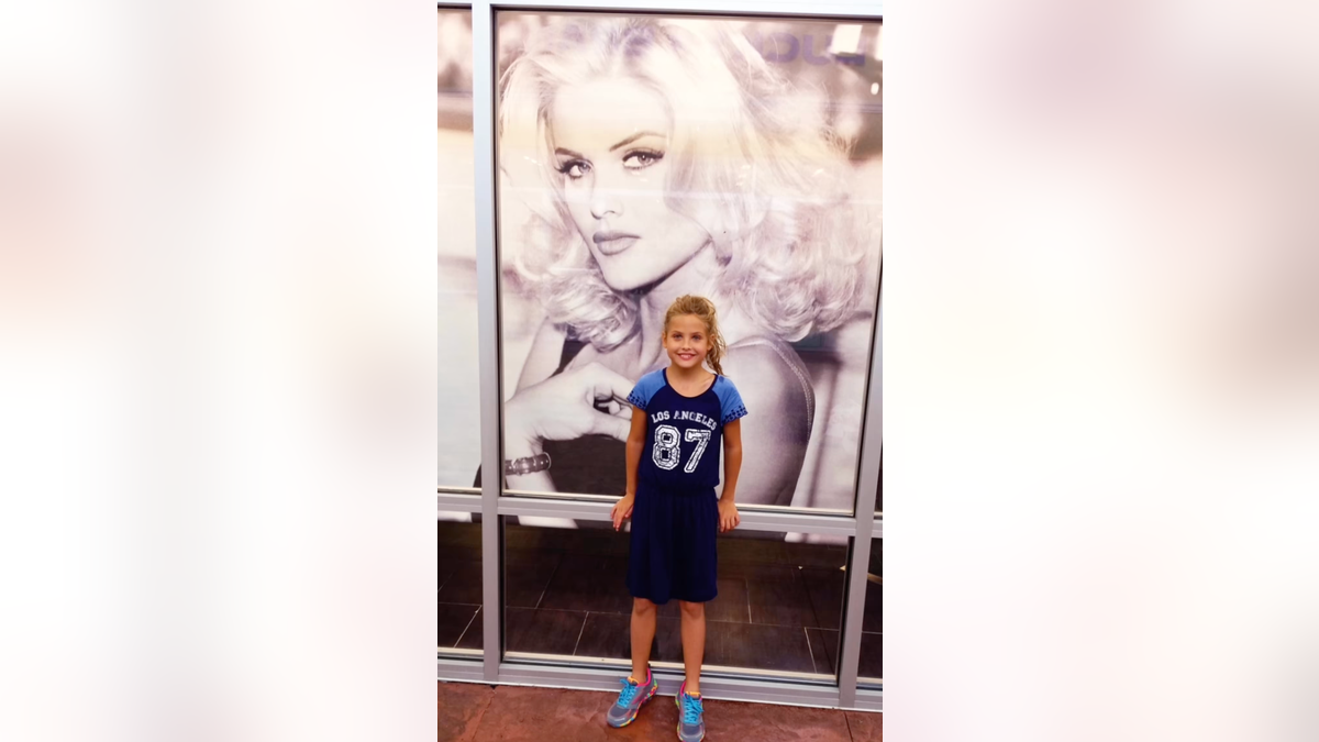 Dannielynn posing with photo of Anna Nicole Smith