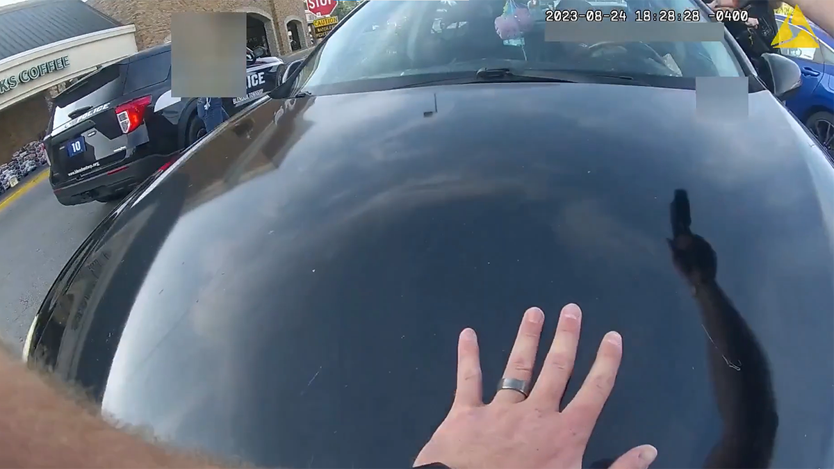 Officer's hand on the front of the vehicle