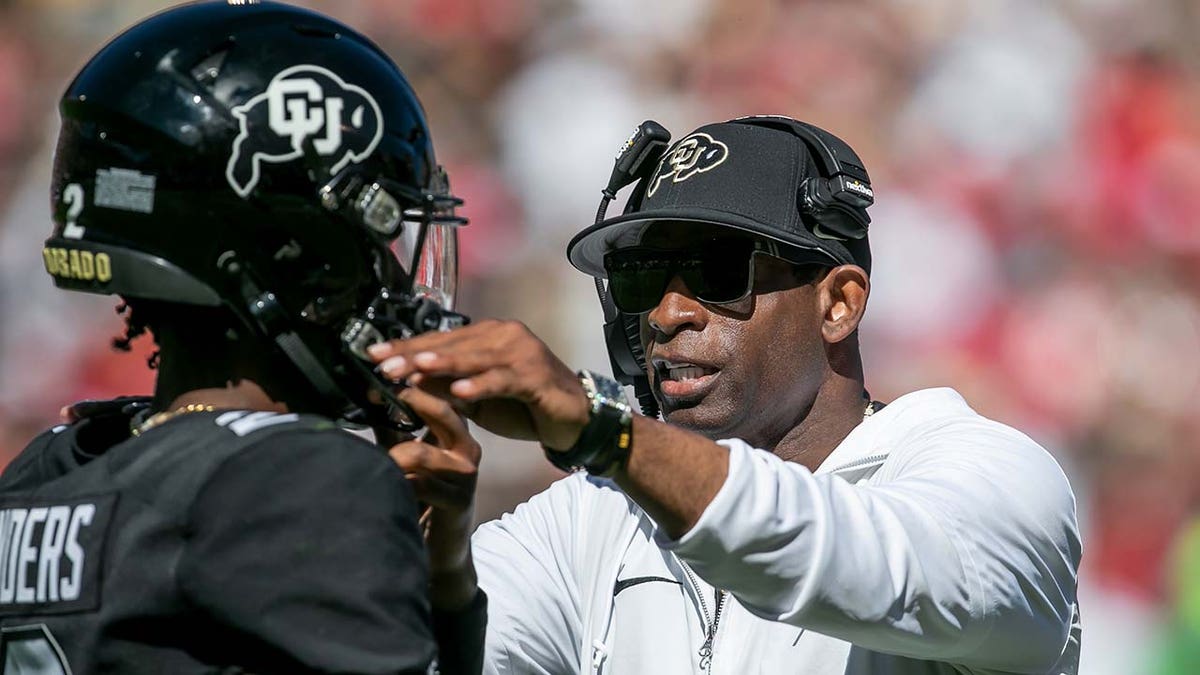 Deion Sanders speaks with Colorado quarterback Shedeur Sanders
