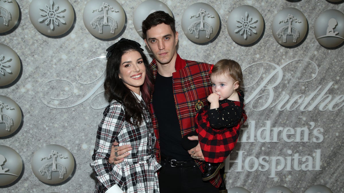 Shenae Grimes-Beech and Josh Beech pose at an even with their daughter 2019