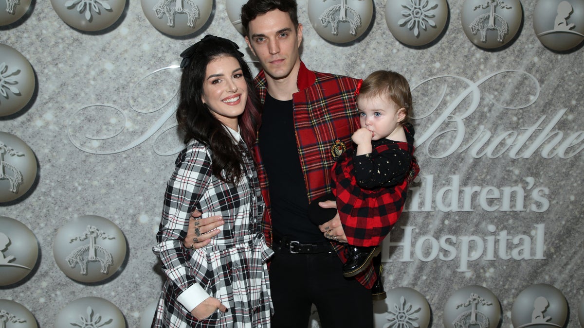 Shenae Grimes-Beech and Josh Beech pose at an even with their daughter 2019