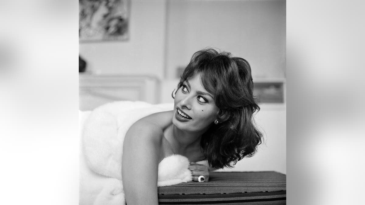 Sophia Loren posing wrapped in a white blanket