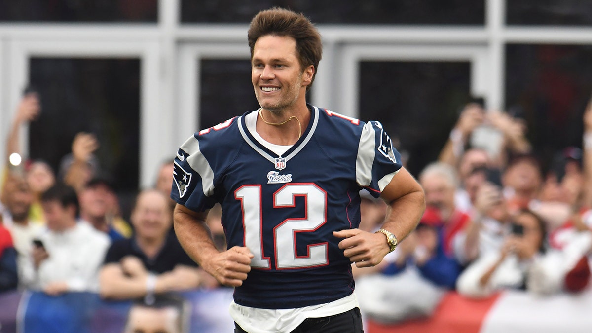 Tom Brady runs onto the field