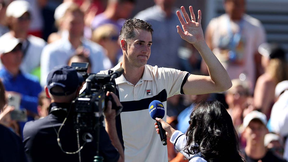 Tennis pro John Isner waves to the crowd