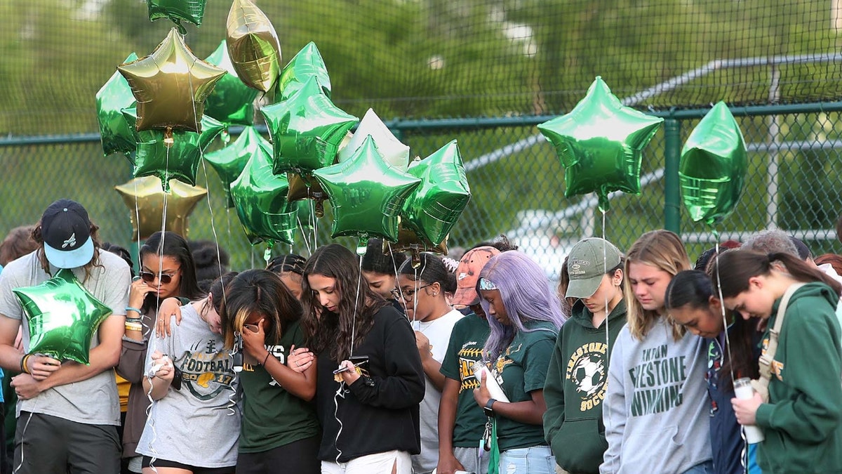 Family and friends gather at the baseball field on Friday evening at Firestone High School in Akron for a vigil for Ethan Liming, 17, a much loved and admired Firestone student who played baseball and football.
