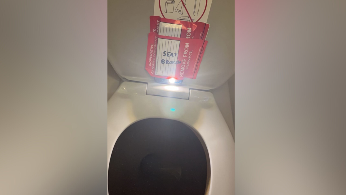 A cell phone taped under a toilet seat on a flight