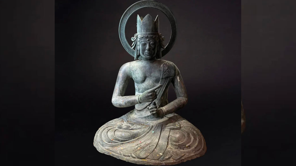 Buddha statue is pictured in black background